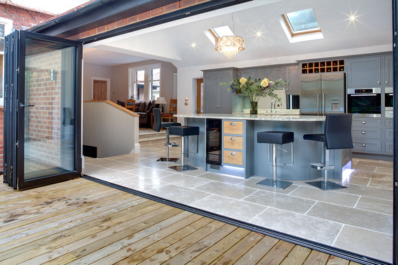 Fabulous grey painted kichen viewd from outside, with bifold sliding doors opened.